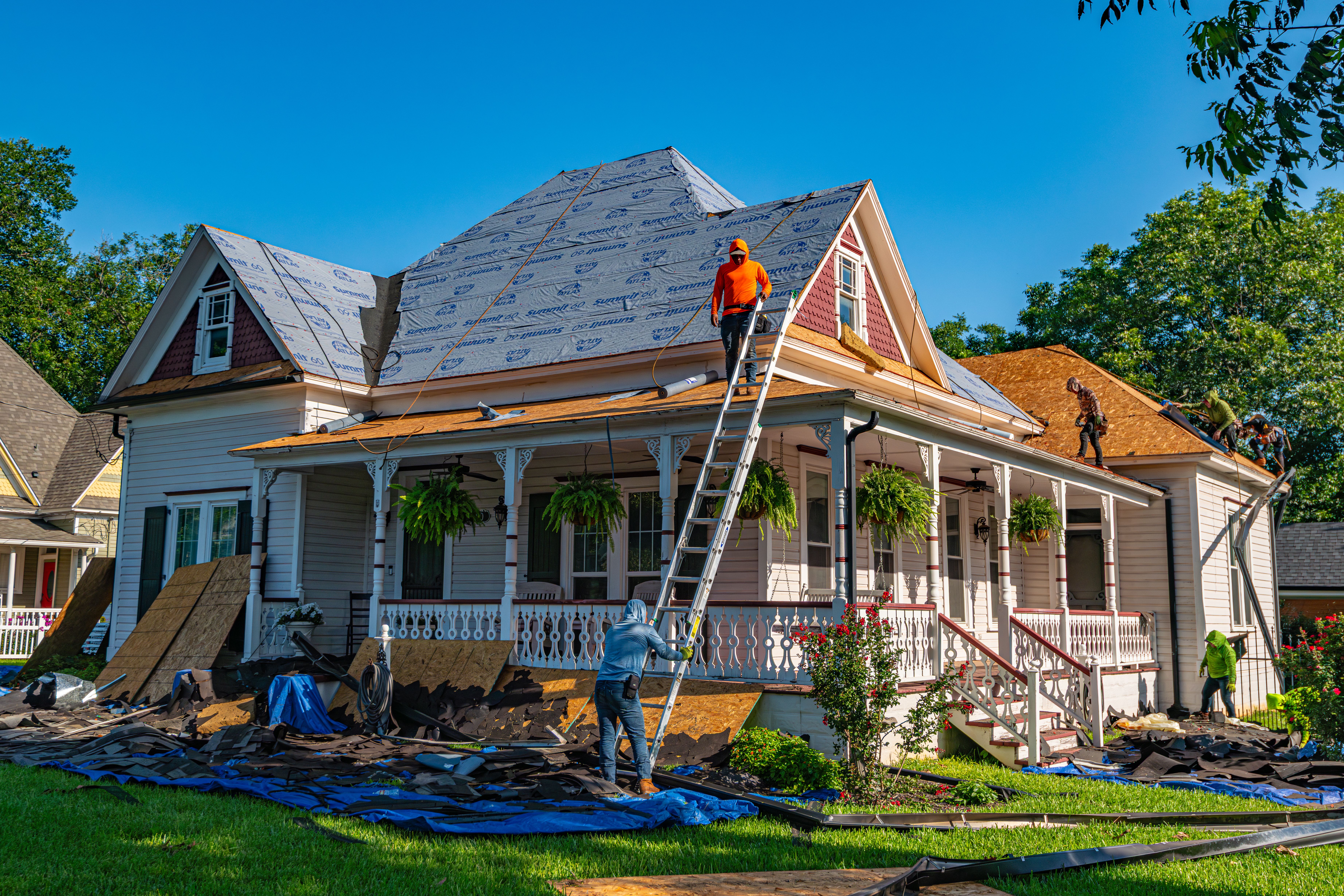 A residential roof replacement in progress with multiple crew members